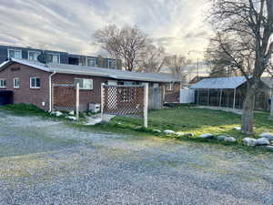 Front side view of duplex with yard, driveway, parking, brick and a shingled roof