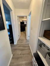 Unit 4365 Hallway with light laminate floors and a textured ceiling