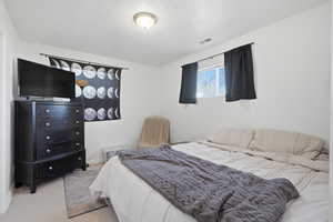 Bedroom with light colored carpet and baseboards