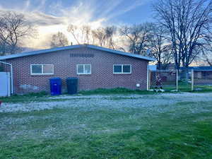 Side view of property with driveway, brick and a lawn