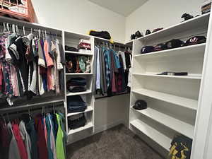 Walk in closet with dark colored carpet