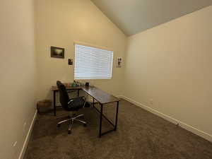 Office featuring lofted ceiling and dark colored carpet