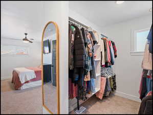 Primary suite walk in closet with light carpet