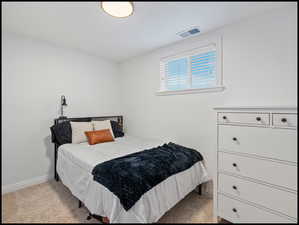 Bedroom featuring light carpet and baseboards