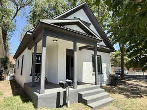 View of front of home featuring brick siding and covered porch