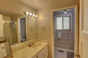 Bathroom with vanity, a shower with door, and tile patterned floors