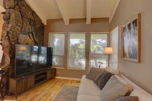 Living area with light wood finished floors and beamed ceiling