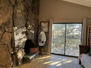 Bedroom featuring lofted ceiling, light wood-type flooring, and access to outside