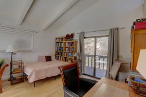 Bedroom featuring a desk, access to exterior, vaulted ceiling, and light wood finished floors