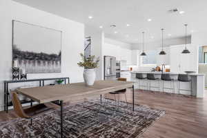 Dining room with dark wood-type flooring and recessed lighting