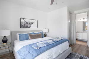 Bedroom with wood finished floors, ceiling fan, and connected bathroom