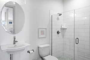 Full bathroom featuring toilet and a shower stall