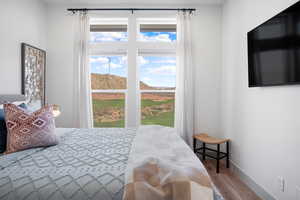 Bedroom with wood finished floors and baseboards