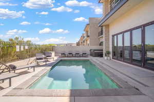 View of pool with patio surround and a hot tub