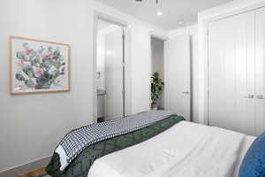 Bedroom with recessed lighting, wood finished floors, and ensuite bath