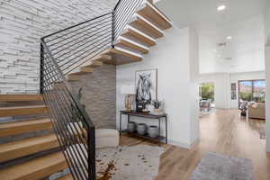 Stairway with wood finished floors and recessed lighting