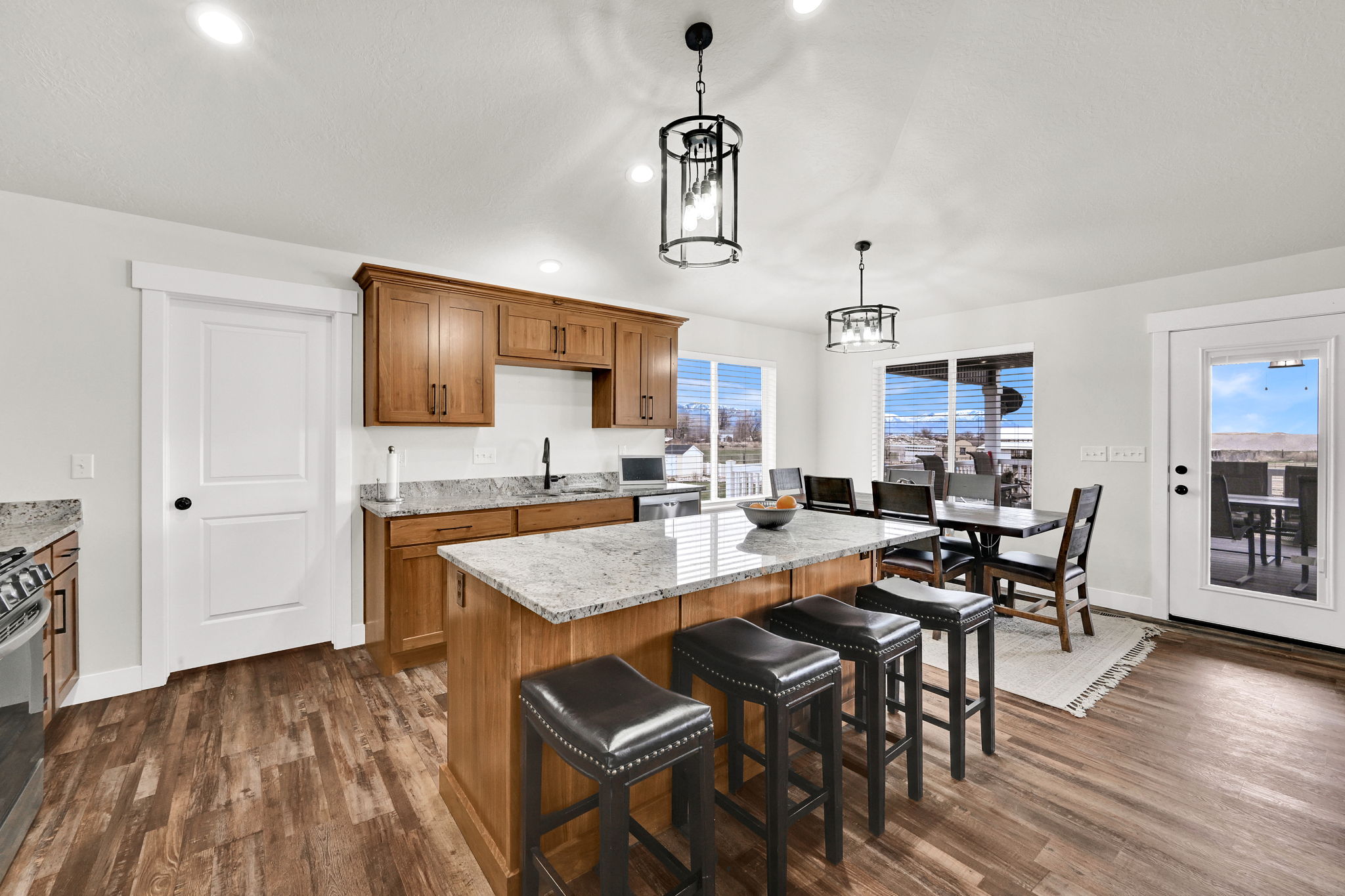 Kitchen with wood finish cabinetry, a breakfast bar area, dark wood-style floors, and light stone counters