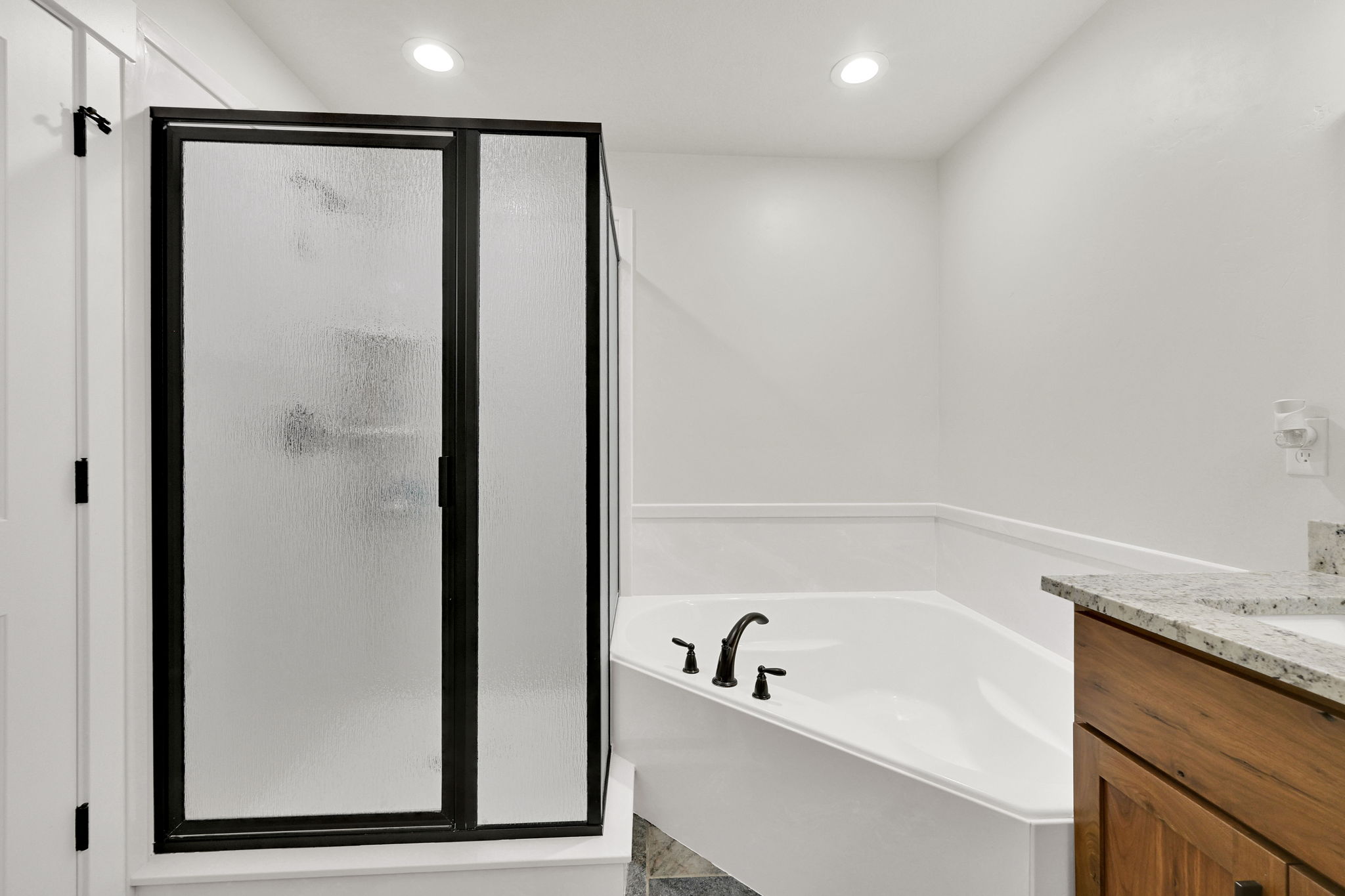 Bathroom with vanity, a shower stall, a garden tub, and recessed lighting