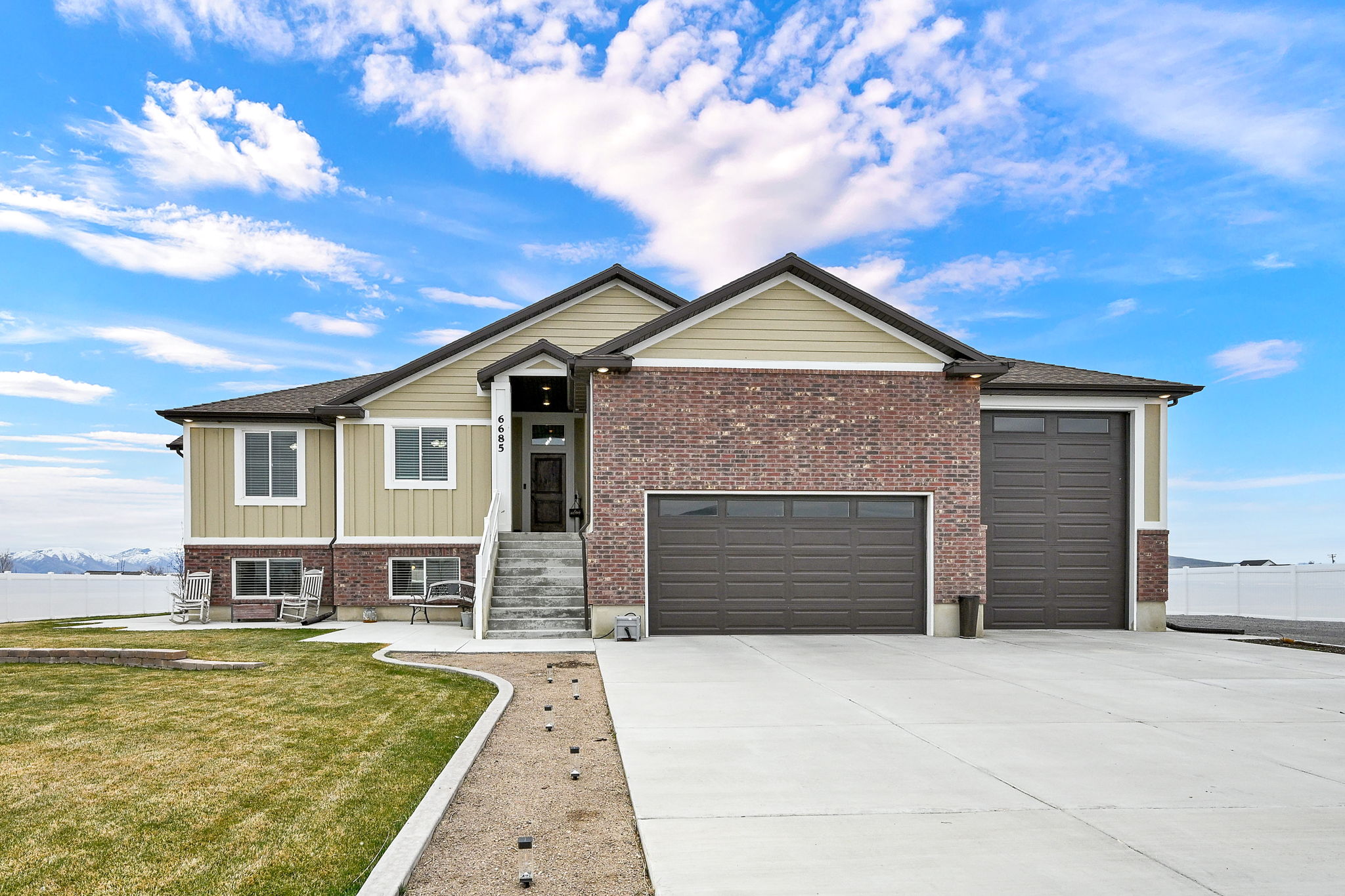 View of front of home with a garage, concrete driveway, a front lawn, and brick siding