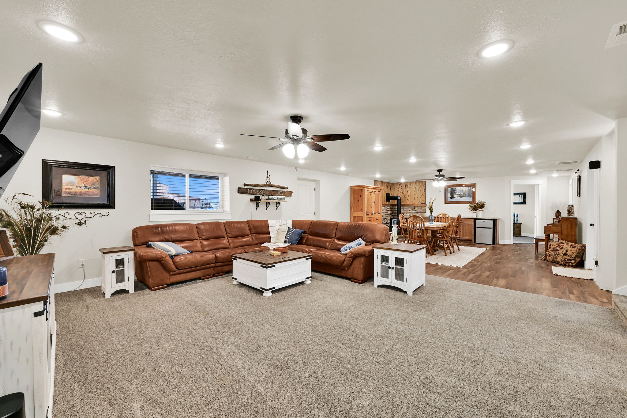 Carpeted living area featuring a ceiling fan and recessed lighting