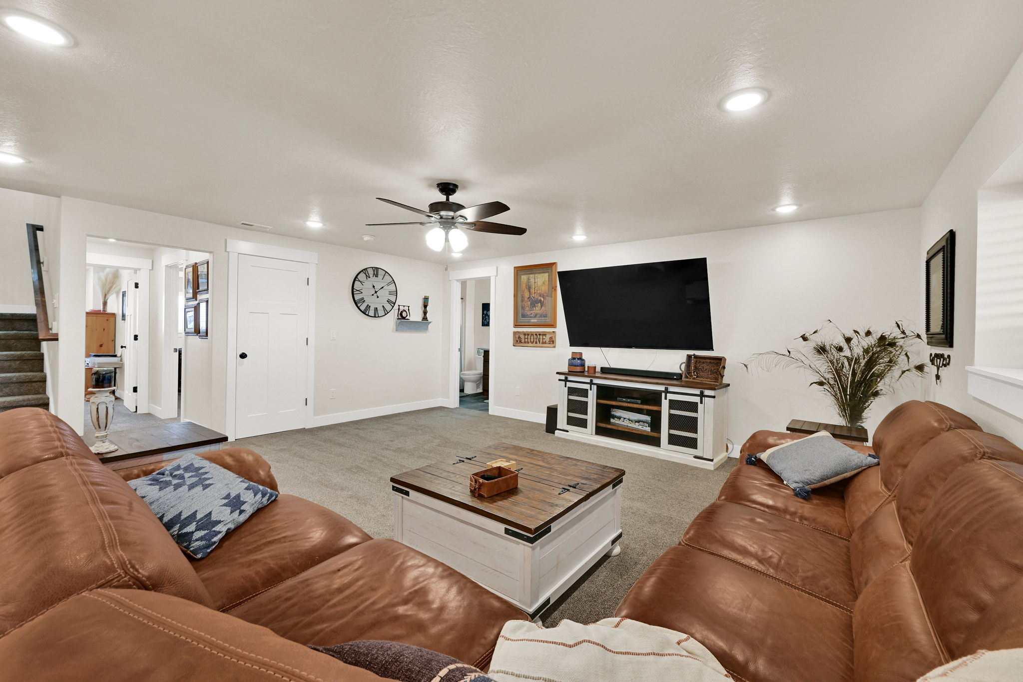 Carpeted living room featuring ceiling fan and recessed lighting