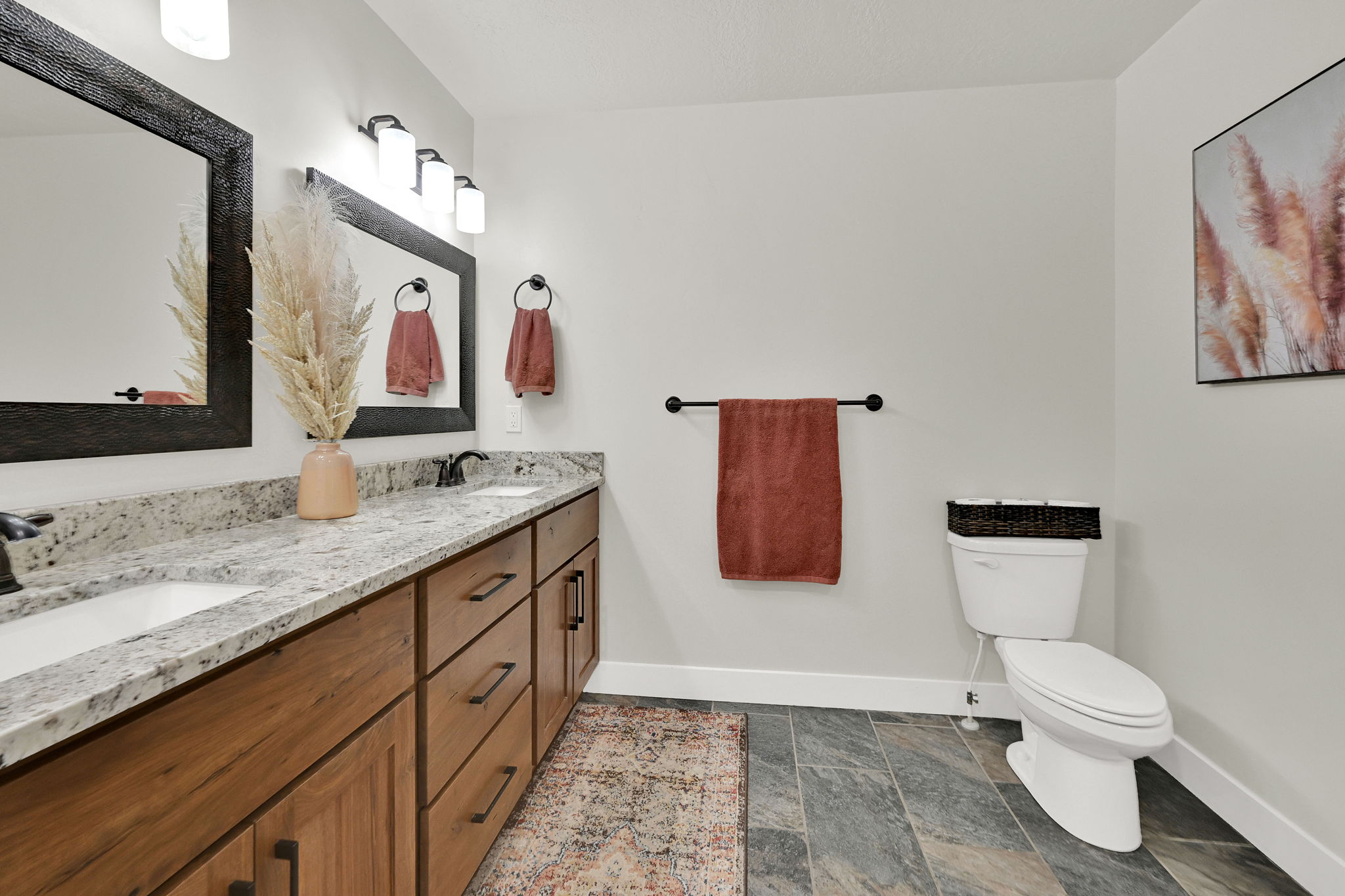 Full bathroom featuring double vanity and stone finish flooring