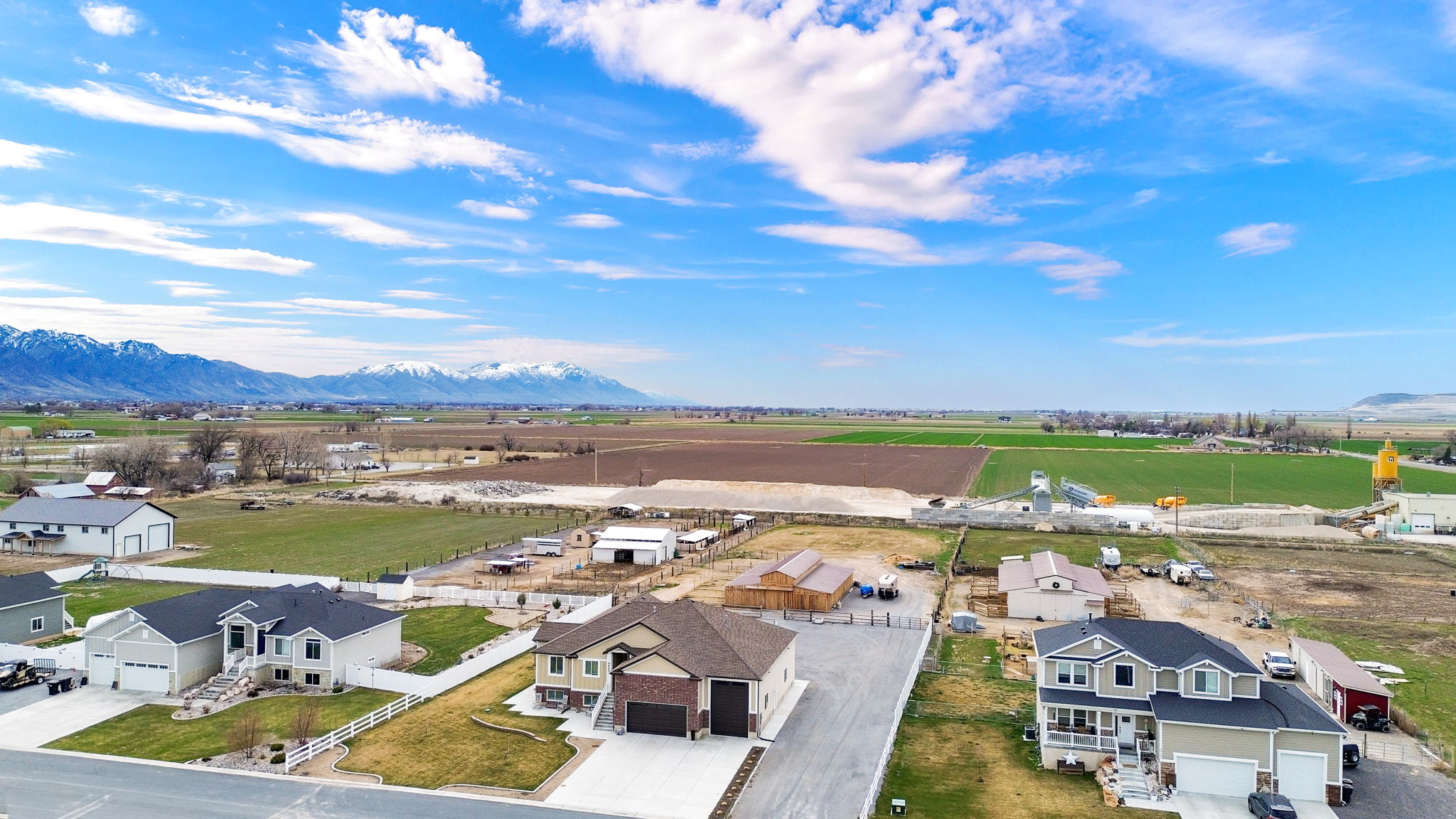 Aerial view of sparsely populated area featuring nearby suburban area and mountains