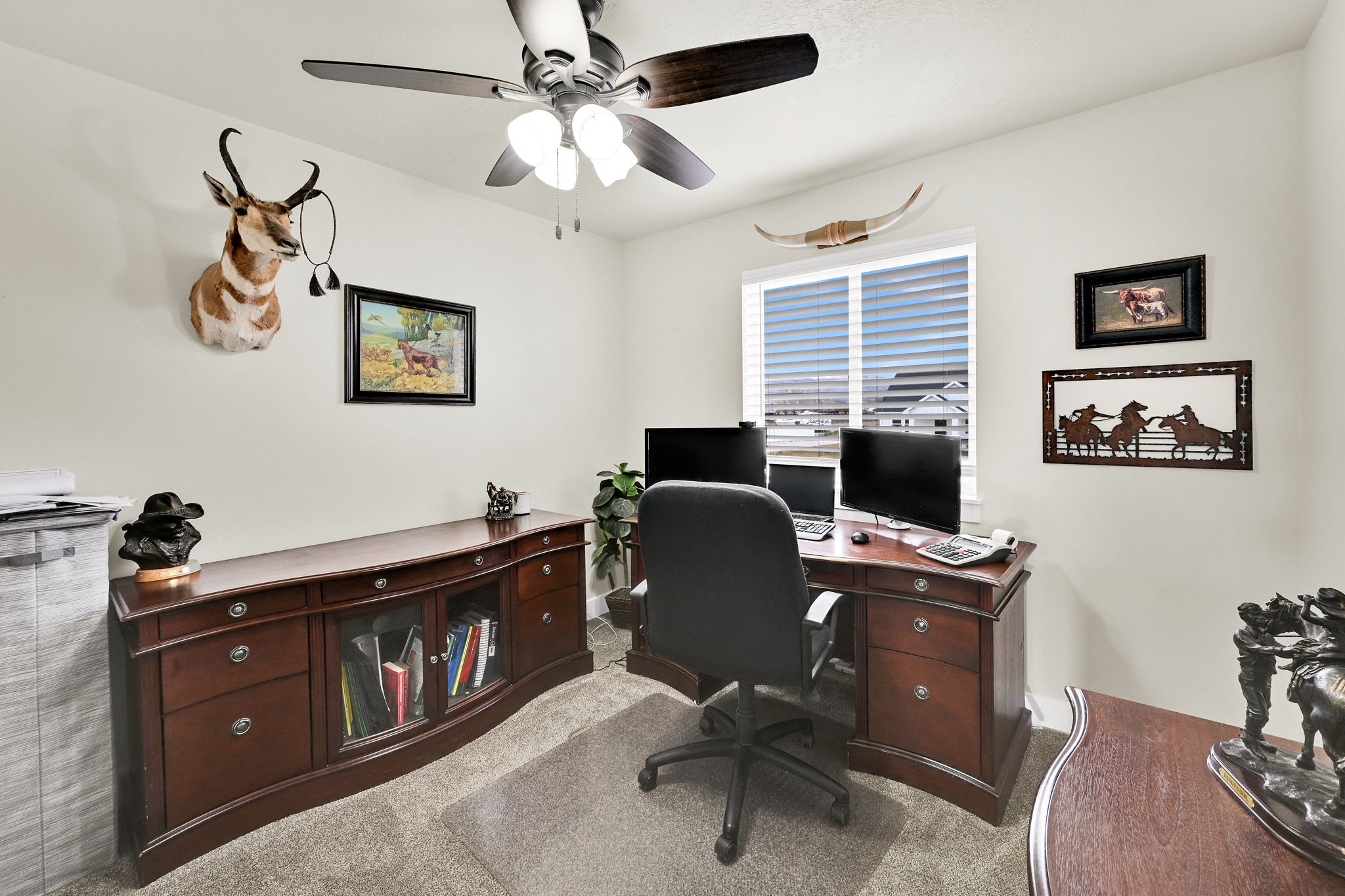 Home office with a ceiling fan and light carpet