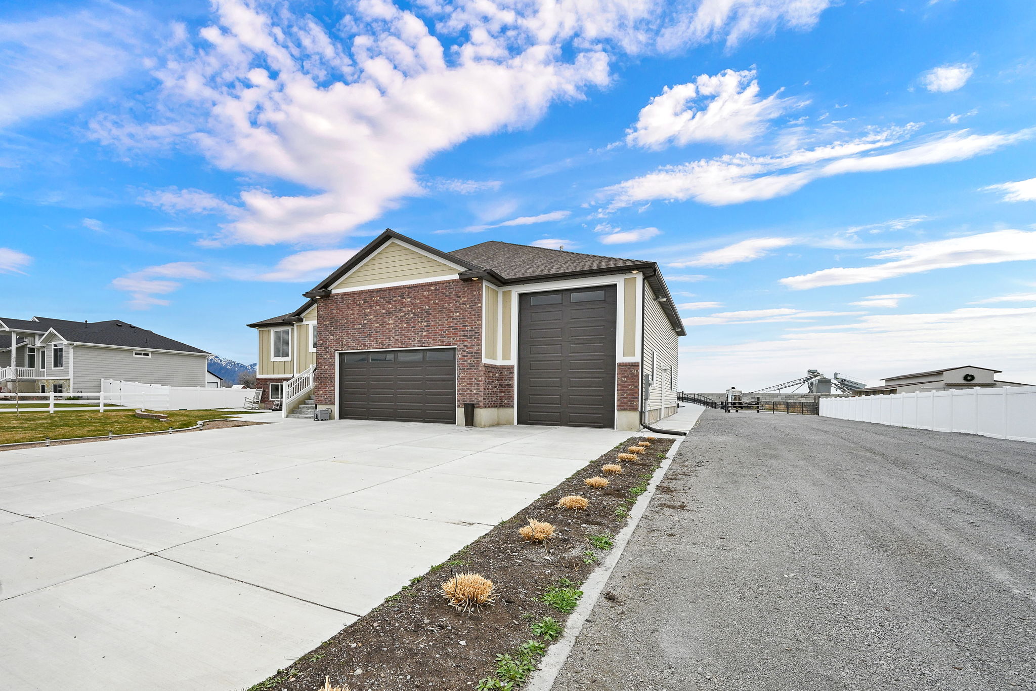 View of home's exterior featuring brick siding, driveway, and a garage