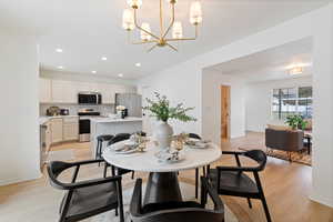 Dining space with light wood-type flooring and suspended lighting