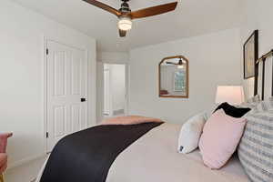 Carpeted bedroom with a ceiling fan and baseboards