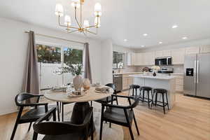 Dining area featuring light wood finished floors and suspended lighting