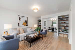 Living room featuring light wood-style floors and a chandelier