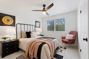Bedroom with light colored carpet and a ceiling fan