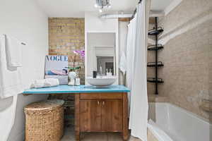 Full bath with vanity, tiled shower / bath combo, and light tile patterned floors