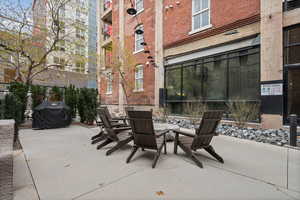 View of patio with area for grilling and a fire pit