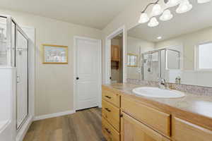 Primary bathroom featuring a shower, vanity, and LVP floors
