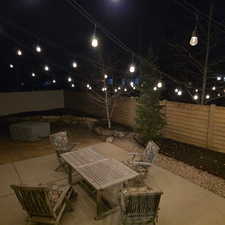 Patio at night with a patio and a fenced backyard