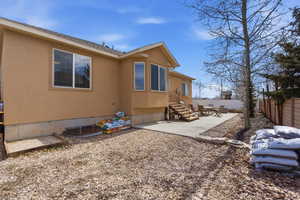 Rear view of property with stucco siding and a patio all low maintenance