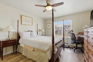 Primary bedroom featuring LVP floors, ceiling fan, and an office area