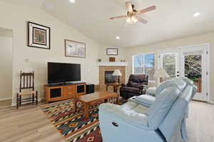 Living area with ceiling fan, light wood finished floors, recessed lighting, vaulted ceiling, and french doors