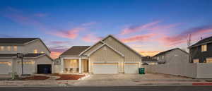 View of front of home with concrete driveway, board and batten siding, and an attached garage