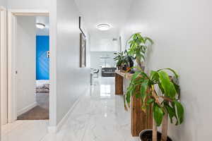 Hallway with light marble finish flooring and a textured ceiling