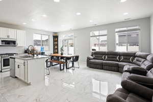 Living area featuring a textured ceiling, recessed lighting, and light marble finish floors
