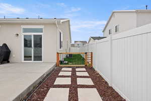 Fenced backyard featuring a patio area and a gate