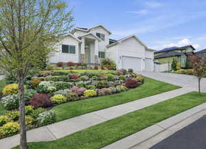 Modern farmhouse with board and batten siding, concrete driveway, a garage, and a gate