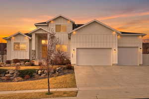 View of front of home with board and batten siding, an attached garage, and driveway