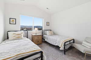 Bedroom with lofted ceiling, dark colored carpet, and a mountain view