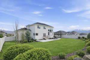 Back of house with a mountain view, a patio, a fenced backyard, and stucco siding