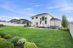 Back of house with a fenced backyard, a patio area, a hot tub, and stucco siding